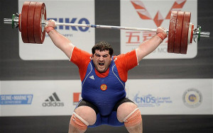 Тяжелоатлет поднимает штангу Подъем тяжелых предметов