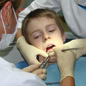 Врач осматривает ребенка Хронический остеомиелит челюсти чаще встречается у детей от трех до двенадцати лет